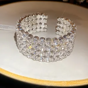 Detail view of a shimmering four-row rhinestone open cuff bracelet in silver tone.