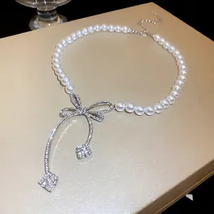 Elegant French style faux pearl necklace with a sparkling rhinestone-encrusted bow pendant