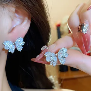 Close-up view of sparkling zircon butterfly stud earrings featuring silver needles