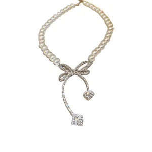 Elegant baroque pearl necklace with a sparkling diamond bow pendant for women jewelry.