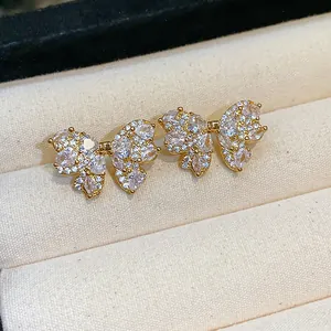 Macro detail of gold-plated bow stud earrings with sparkling cubic zirconia