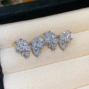 Macro view of delicate butterfly bowknot stud earrings with sparkly pavé set zircons.