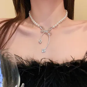 Close-up view of a French style baroque pearl necklace featuring a sparkling rhinestone bow