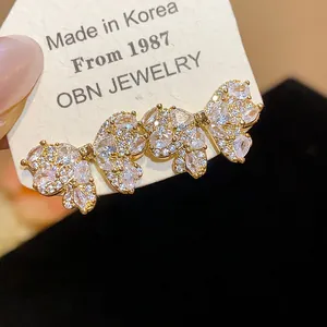 Close-up detail of elegant gold-toned zircon bow-knot stud earrings for a luxury look.