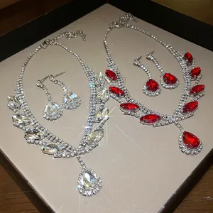 Détail d'élégantes parures de colliers et boucles d'oreilles en strass rouge et clair