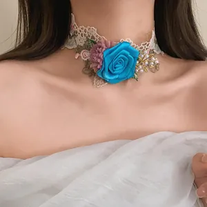 Close-up detail of a French lace choker featuring a blue fabric rose and pearl accents