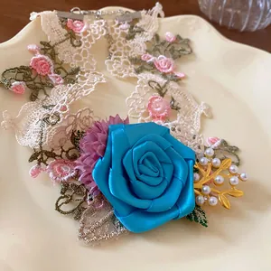 Detail of a French style floral lace choker with a large blue rose and elegant pearls