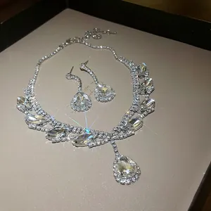 Détail d'un luxueux ensemble collier et boucles d'oreilles en strass argentés étincelants.