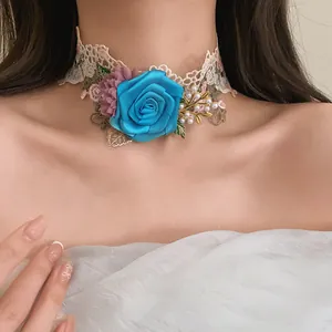 Close-up of an elegant lace choker with a large blue fabric rose and pearl accents
