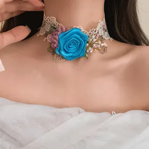Detail of French luxury lace choker with a large blue fabric rose and pearls on a model.