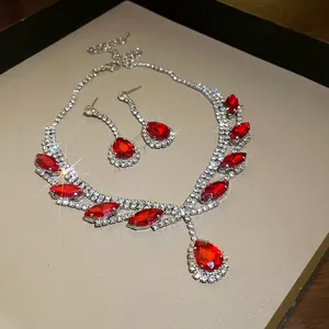 Détail d'une parure de bijoux avec pierres rouges, collier et boucles d'oreilles.