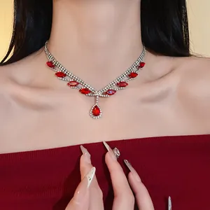 Gros plan d'un élégant collier argenté avec strass et pendentif rouge sur le cou
