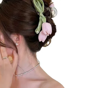 Eleganter Haarclip mit rosa Tulpen und grüner Schleife für süße sommerliche Frisuren.