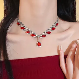 Vue détaillée d'un collier argenté élégant avec des pierres rouges marquises et poires.