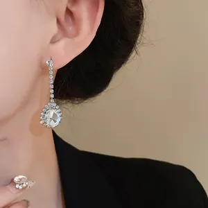 Gros plan de boucles d'oreilles pendantes en goutte avec strass sur un modèle