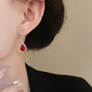 Gros plan sur une boucle d'oreille élégante avec pierre rouge en goutte d'eau.