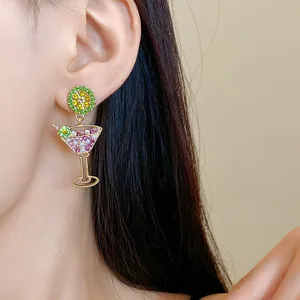 Detail shot of a creative cocktail glass earring with pearls and sparkling lime slice charm