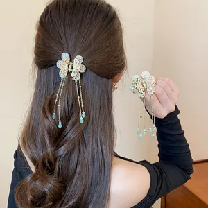 Close-up view of an elegant ancient style butterfly tassel hair clip on hair and hand