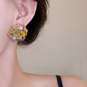 Close-up of vintage floral pearl stud earrings in gold with elegant jewelry details.