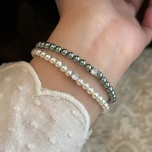 Vue détaillée de bracelets élégants en perles blanches et grises avec accents zircon