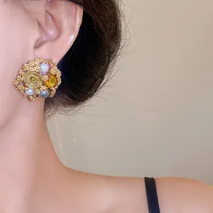 Vintage floral stud earring with pearls and crystals shown on model ear