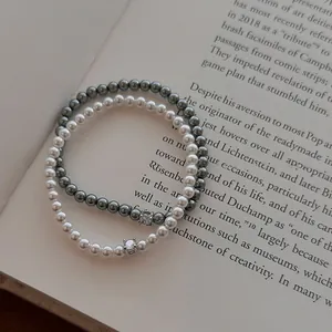 Vue détaillée de bracelets de perles en zircon rétro sur fond de livre ouvert élégant