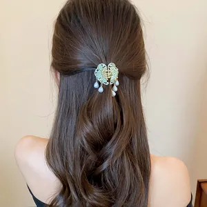 Close-up of an elegant butterfly hair claw clip with tassels worn on a half-up hairstyle.