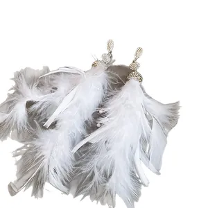 Eleganti orecchini pendenti con piume bianche e borchie di cristallo strass brillanti