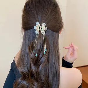 Detailed view of elegant butterfly hair claw clip with long tassels and beads.