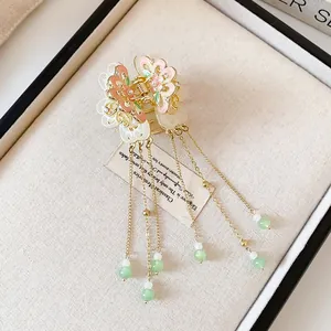 Detail view of an elegant butterfly tassel hair clip with green beads in vintage Chinese style