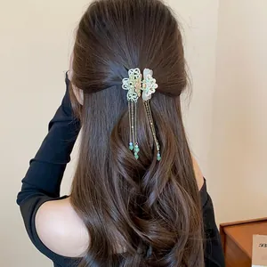 Vintage enamel butterfly hair claw clip with elegant dangling tassels styled on long brown hair