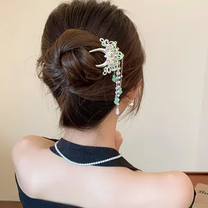 Classical butterfly hair clip with long pearl tassels shown in an elegant bun hairstyle
