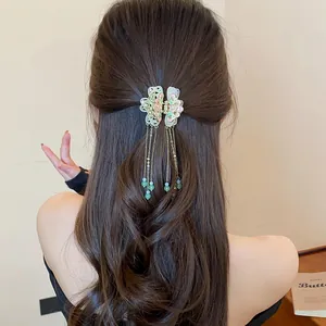 Detailed view of an elegant Chinese style butterfly hair claw with long bead tassels on model