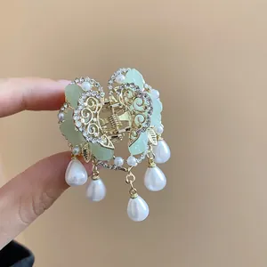 Detailed view of a Chinese-style butterfly hair claw clip with pearls and tassels.