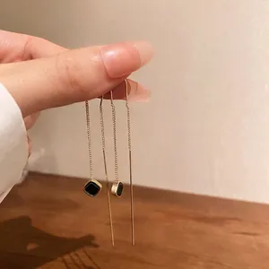 Eleganti orecchini minimalisti a catena lunga d'oro con un ciondolo quadrato nero