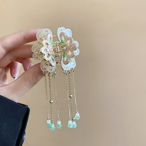 Detailed view of elegant vintage butterfly hair claw clip with long golden tassels and beads