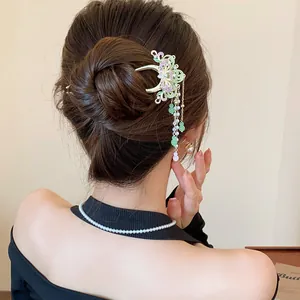 Detail view of an elegant ancient-style butterfly hair claw clip with tassels on a bun
