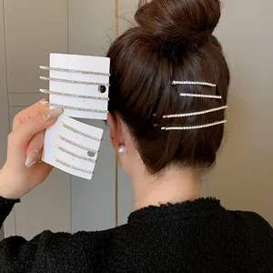 Primo piano di fermagli per capelli con strass scintillanti indossati e su schede