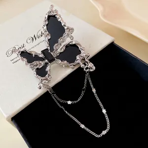 Eleganter silberner Schmetterlingsbroschen mit schwarzem Inlay und Ketten für Mäntel