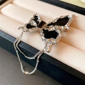 Eleganter silberner Schmetterling-Brosche mit schwarzem Inlay und feiner Sternenkette