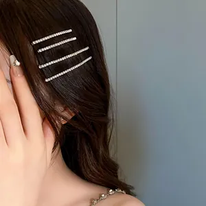 Dettaglio di quattro eleganti fermagli per capelli con strass per un look luminoso e chic.
