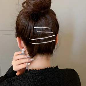 Dettaglio di eleganti fermagli per capelli in strass argento su uno chignon minimalista