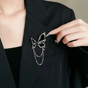 Detailansicht einer eleganten silbernen Schmetterlingsbrosche mit schwarzem Stein und Quasten