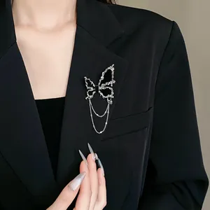 Elegante silberne Schmetterlingsbrosche mit Quastenketten an einem schwarzen Damenblazer