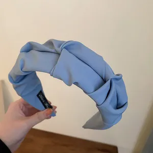 Close-up detail view of a stylish light blue ruched fabric headband for women's hair accessory