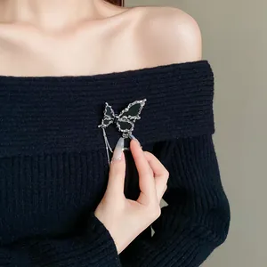 Detailaufnahme einer eleganten silbernen Schmetterlingsbrosche mit schwarzen Flügeln