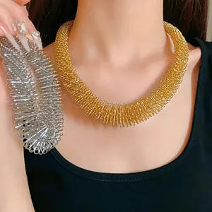 Detailaufnahme der metallischen Textur von goldenen und silbernen Feder-Choker-Halsketten