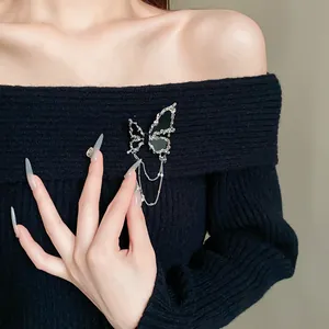 Detailansicht einer exquisiten Schmetterlingsbrosche mit Strasssteinen auf Strickware