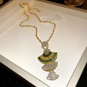 Elegant vintage gold necklace featuring a green and white crystal fan-shaped tiered pendant
