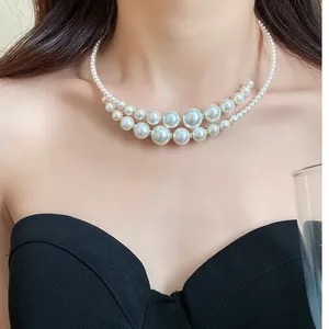 Vista dettagliata di un'elegante collana girocollo a due fili di perle irregolari su modella